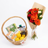Get Well Soon Basket seen from above with teas, vitamins and lemons next to an orange gerbera bouquet