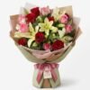 Lily & Roses bouquet of white lilies with red and pink roses in pink and green wrap with a bow