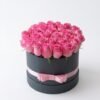 Pink Bloom Round Box: pink roses in a dark grey round box with a pink ribbon bow
