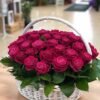 Radiant Ruby Basket: deep pink-red roses with leaves in a white wicker basket with a handle